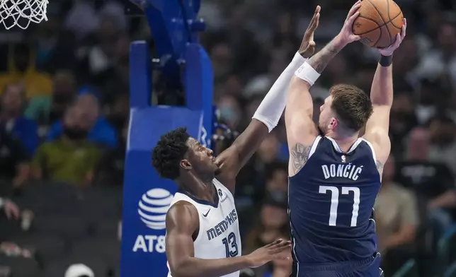 Dallas Mavericks guard Luka Doncic (77) goes up for a basket against Memphis Grizzlies forward Jaren Jackson Jr. (13) during the first half of an Emirates NBA Cup basketball game, Tuesday, Dec. 3, 2024, in Dallas. (AP Photo/Julio Cortez)