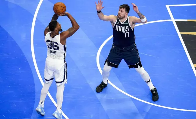 Memphis Grizzlies guard Marcus Smart (36) shoots against Dallas Mavericks guard Luka Doncic (77) during the second half of an Emirates NBA Cup basketball game, Tuesday, Dec. 3, 2024, in Dallas. The Mavericks won 121-116. (AP Photo/Julio Cortez)