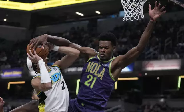 Indiana Pacers' Andrew Nembhard (2) is fouled by New Orleans Pelicans' Yves Missi (21) during the first half of an NBA basketball game, Sunday, Dec. 15, 2024, in Indianapolis. (AP Photo/Darron Cummings)