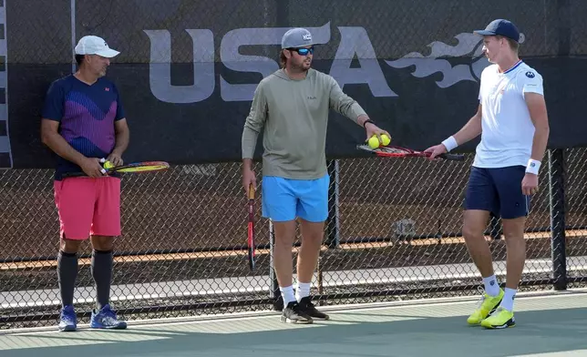 Tennis coaches Eric Nunez, left, and Rhyne Williams, center, work with Jenson Brooksby, right, at the USTA national campus Tuesday, Dec. 10, 2024, in Orlando, Fla. (AP Photo/John Raoux)