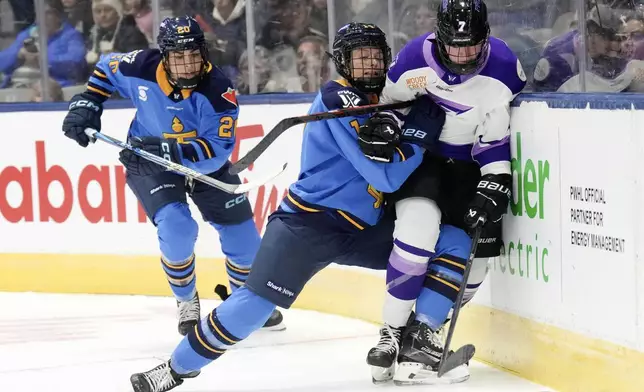 Toronto Sceptres' Renata Fast (14) battles along the boards with Minnesota Frost's Claire Butorac (7) during the first period of a PWHL hockey game, Saturday, Dec. 7, 2024. (Chris Young/The Canadian Press via AP)