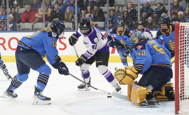 Minnesota Frost's Denisa Krizova (41) battles for the puck with Toronto Sceptres' Allie Munroe (12) in front of Toronto goaltender Kristen Campbell (50) during the first period of a PWHL hockey game, Saturday, Dec. 7, 2024. (Chris Young/The Canadian Press via AP)