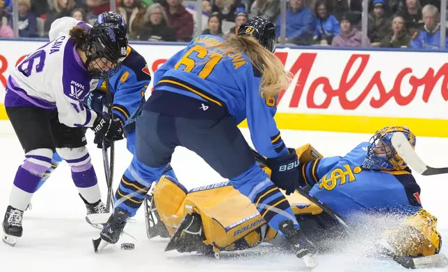 Toronto Sceptres goaltender Kristen Campbell (50) scrambles to get the puck clear of Minnesota Frost's Michela Cava (86) during the third period of a PWHL hockey game, Saturday, Dec. 7, 2024. (Chris Young/The Canadian Press via AP)