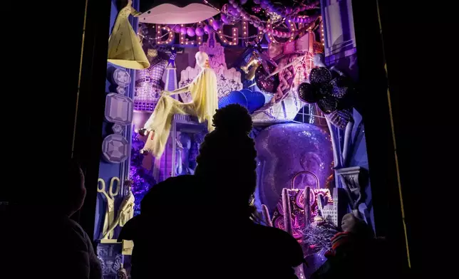 People look at a Bergdorf Goodman window display on Fifth Avenue, Saturday, Dec. 14, 2024, in New York. (AP Photo/Julia Demaree Nikhinson)