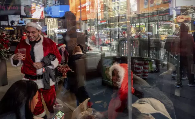 Revellers take part in SantaCon, Saturday, Dec. 14, 2024, in New York. (AP Photo/Julia Demaree Nikhinson)