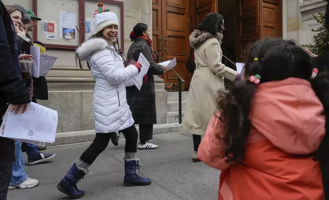 Janice Annunziata smiles at Catarina, 4, while taking part in the West Village Chorale's 50th annual Greenwich Village caroling walk, Sunday, Dec. 15, 2024, in New York. (AP Photo/Julia Demaree Nikhinson)