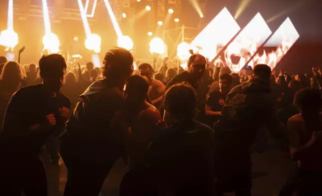 People slam during the presentation of the music album Epoch, a collaboration between Ukrainian artists and the 3rd Assault Brigade, in Kyiv, Ukraine, Saturday, Dec. 7, 2024. (AP Photo/Alex Babenko)