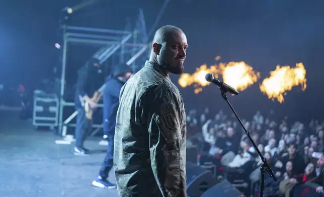 Ukrainian serviceman of 3rd Assault Brigade known by call sign "Avdei" performs together with rock band Proroky, during the presentation of the music album Epoch, a collaboration between Ukrainian artists and the 3rd Assault Brigade, in Kyiv, Ukraine, Saturday, Dec. 7, 2024. (AP Photo/Alex Babenko)