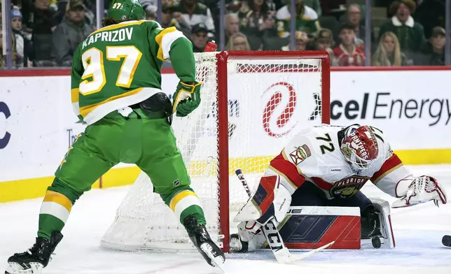 Florida Panthers goaltender Sergei Bobrovsky, right, makes a save on a shot by Minnesota Wild left wing Kirill Kaprizov (97) during the first period of an NHL hockey game Wednesday, Dec. 18, 2024, in St. Paul, Minn. (AP Photo/Matt Krohn)