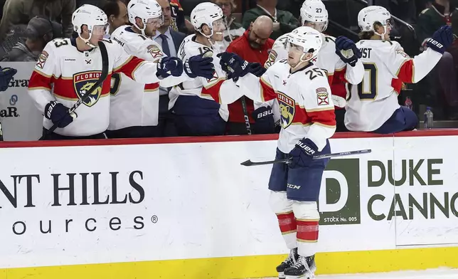 Florida Panthers right wing Mackie Samoskevich (25) is congratulated for his goal against the Minnesota Wild during the first period of an NHL hockey game Wednesday, Dec. 18, 2024, in St. Paul, Minn. (AP Photo/Matt Krohn)