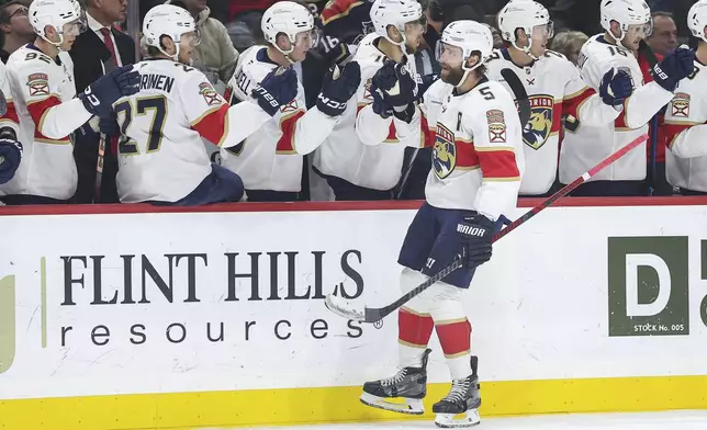 Florida Panthers defenseman Aaron Ekblad is congratulated for his goal against the Minnesota Wild during the first period of an NHL hockey game Wednesday, Dec. 18, 2024, in St. Paul, Minn. (AP Photo/Matt Krohn)