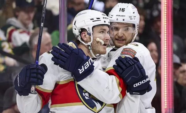 Florida Panthers left wing Matthew Tkachuk, left, celebrates his goal with center Aleksander Barkov during the second period of an NHL hockey game against the Minnesota Wild Wednesday, Dec. 18, 2024, in St. Paul, Minn. (AP Photo/Matt Krohn)