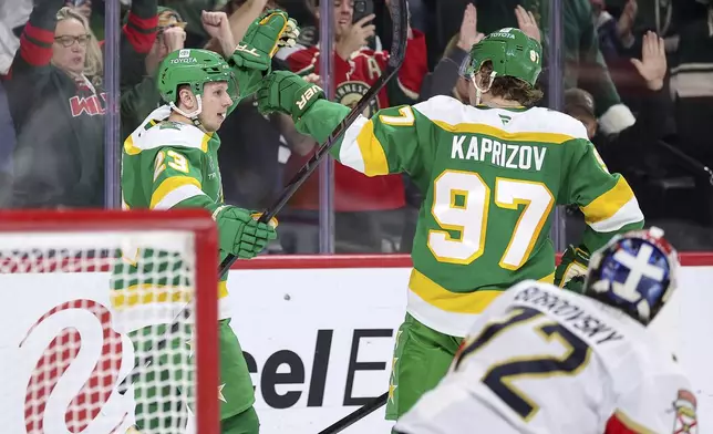 Minnesota Wild center Marco Rossi, left, celebrates his power-play goal with left wing Kirill Kaprizov (97) during the first period of an NHL hockey game against the Florida Panthers Wednesday, Dec. 18, 2024, in St. Paul, Minn. (AP Photo/Matt Krohn)