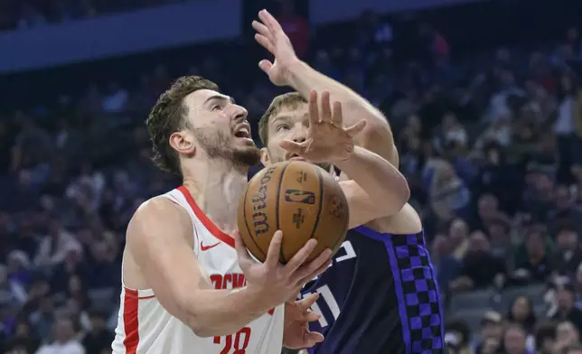 Houston Rockets center Alperen Sengun, left, drives past Sacramento Kings forward Domantas Sabonis during the first half of an Emirates NBA Cup basketball game in Sacramento, Calif., Tuesday, Dec. 3, 2024. (AP Photo/Randall Benton)