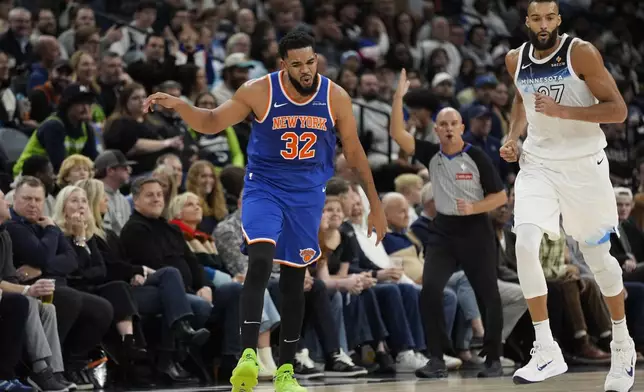 New York Knicks center Karl-Anthony Towns (32) celebrates after making a 3-point shot over Minnesota Timberwolves center Rudy Gobert (27) during the first half of an NBA basketball game, Thursday, Dec. 19, 2024, in Minneapolis. (AP Photo/Abbie Parr)