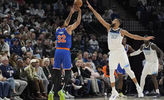 New York Knicks center Karl-Anthony Towns (32) shoots over Minnesota Timberwolves center Rudy Gobert (27) during the first half of an NBA basketball game, Thursday, Dec. 19, 2024, in Minneapolis. (AP Photo/Abbie Parr)