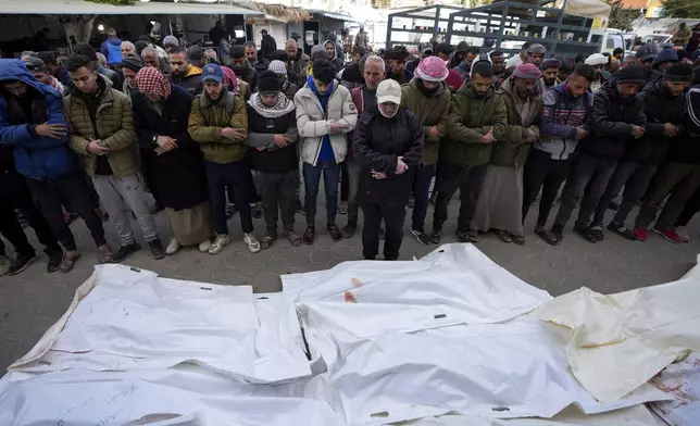 Palestinians attend funeral prayers over the bodies of those killed in overnight Israeli airstrikes on the Maghazi refugee camp, at Al-Aqsa Hospital, in Deir al-Balah, central Gaza Strip, Saturday, Dec. 28, 2024. (AP Photo/Abdel Kareem Hana)