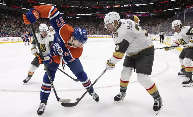 Vegas Golden Knights' Brayden McNabb (3) and Edmonton Oilers' Connor McDavid (97) battle for the puck during the second period of an NHL game in Edmonton, Alberta, Saturday, Dec. 14, 2024. (Jason Franson/The Canadian Press via AP)