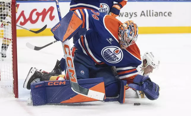 Vegas Golden Knights' Brett Howden (21) tries for the rebound on the save from Edmonton Oilers goalie Stuart Skinner (74) during the third period of an NHL game in Edmonton, Alberta, Saturday, Dec. 14, 2024. (Jason Franson/The Canadian Press via AP)