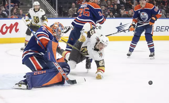 Vegas Golden Knights' Brett Howden (21) tries for the rebound on the save from Edmonton Oilers goalie Stuart Skinner (74) during the third period of an NHL game in Edmonton, Alberta, Saturday, Dec. 14, 2024. (Jason Franson/The Canadian Press via AP)