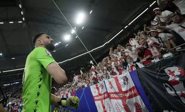 FILE - Georgia's goalkeeper Giorgi Mamardashvili celebrates with fans after a Group F match between Georgia and Portugal at the Euro 2024 soccer tournament in Gelsenkirchen, Germany, Wednesday, June 26, 2024. (AP Photo/Alessandra Tarantino, File)