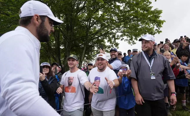 FILE - Scottie Scheffler is greeted by fans wearing T-shirts with Scheffler's booking photo after the second round of the PGA Championship golf tournament at the Valhalla Golf Club, Friday, May 17, 2024, in Louisville, Ky. (AP Photo/Matt York, File)