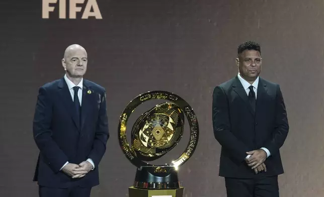 FIFA President Gianni Infantino' and Former professional Brazilian soccer player Ronaldo present a new trophy during the draw for the 2025 FIFA Club World Cup soccer tournament, Thursday, Dec. 5, 2024, in Miami. (AP Photo/Rebecca Blackwell)