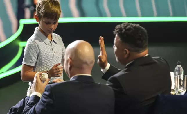 FIFA President Gianni Infantino' and Former professional Brazilian soccer player Ronaldo speak with Ivanka Trump's son Theodore during the draw for the 2025 FIFA Club World Cup soccer tournament, Thursday, Dec. 5, 2024, in Miami. (AP Photo/Rebecca Blackwell