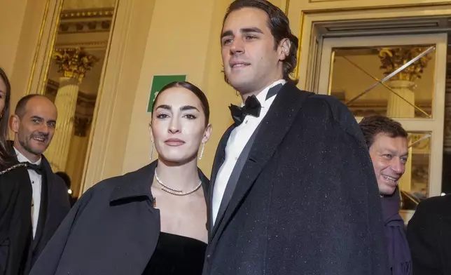 Olympic medallist Gianmarco Tamberi and wife Chiara Bontempi, left, pose for photographers as they arrive at Milan's Opera House La Scala, northern Italy, for the opening of the 2024-25 season featuring Giuseppe Verdi's 'La Forza del destino', Saturday, Dec. 7, 2024. (AP Photo/Luca Bruno)