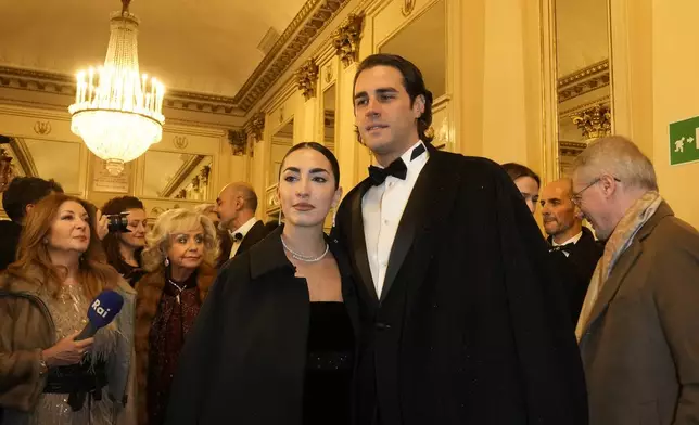 Olympic medallist Gianmarco Tamberi and wife Chiara Bontempi, left, pose for photographers as they arrive at Milan's Opera House La Scala, northern Italy, for the opening of the 2024-25 season featuring Giuseppe Verdi's 'La Forza del destino', Saturday, Dec. 7, 2024. (AP Photo/Luca Bruno)