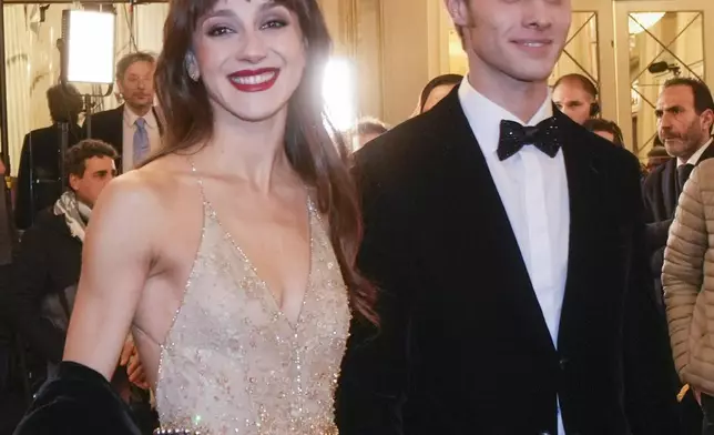 Etoiles Nicoletta Manni, left, and Timofej Andrijashenko pose for photographers as they arrive at Milan's Opera House La Scala, northern Italy, for the opening of the 2024-25 season featuring Giuseppe Verdi's 'La Forza del destino', Saturday, Dec. 7, 2024. (AP Photo/Luca Bruno)