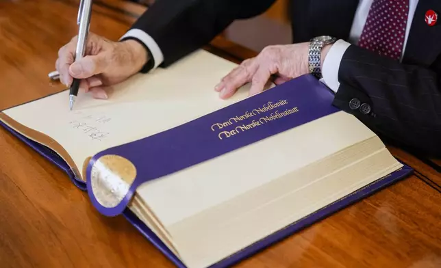 Representative of this year's Nobel Peace Prize winner Nihon Hidankyo, or the Japan Confederation of A- and H-Bomb Sufferers Organizations, Terumi Tanaka signs the guest book ahead of the Nobel Peace Prize ceremony, at the Nobel Institute in Oslo, on Monday, Dec. 9, 2024. (Javad Parsa/NTB Scanpix via AP)