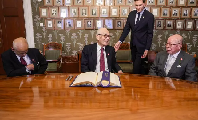 Representatives of this year's Nobel Peace Prize winner Nihon Hidankyo, or the Japan Confederation of A- and H-Bomb Sufferers Organizations, from left; Toshiyuki Mimaki, Terumi Tanaka and Shigemitsu Tanaka, sign the guest book ahead of the Nobel Peace Prize ceremony, at the Nobel Institute in Oslo, on Monday, Dec. 9, 2024. (Javad Parsa/NTB Scanpix via AP)