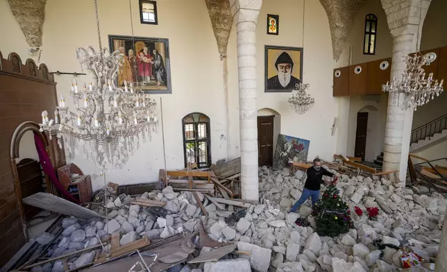 Georges Elia decorates a Christmas tree inside St. George Melkite Catholic Church, that was destroyed by Israeli airstrike, in the town of Dardghaya in southern Lebanon, Sunday, Dec. 22, 2024. (AP Photo/Hassan Ammar)