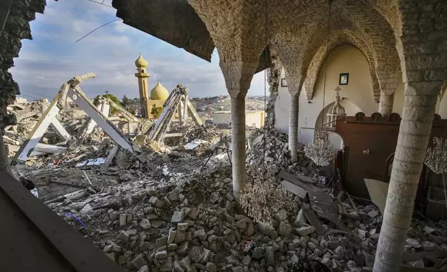 A mosque is seen from St. George Melkite Catholic Church, that was destroyed by Israeli airstrike, in the town of Dardghaya in southern Lebanon, Sunday, Dec. 22, 2024. (AP Photo/Hassan Ammar)