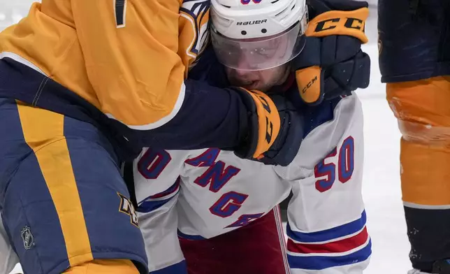 Nashville Predators defenseman Marc Del Gaizo (7) fights New York Rangers left wing Will Cuylle (50) during the second period of an NHL hockey game Tuesday, Dec. 17, 2024, in Nashville, Tenn. (AP Photo/George Walker IV)