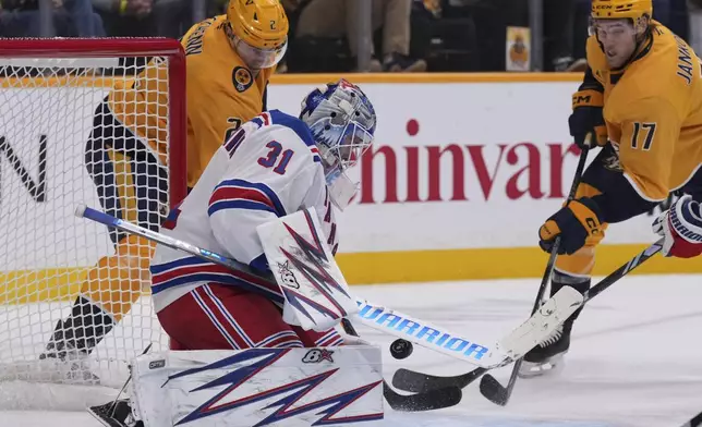 New York Rangers goaltender Igor Shesterkin (31) blocks a shot on goal by Nashville Predators defenseman Luke Schenn (2) during the second period of an NHL hockey game Tuesday, Dec. 17, 2024, in Nashville, Tenn. (AP Photo/George Walker IV)