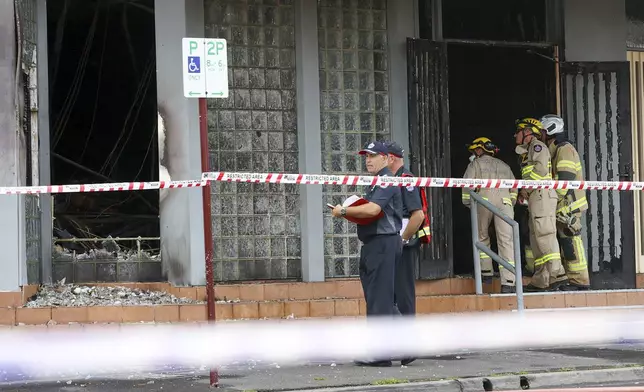 Fire crew members and police officers work the scene of a fire at Adass Israel Synagogue in the suburb of Ripponlea, Melbourne, Australia, Friday, Dec. 6, 2024. (Con Chronis/AAP Image via AP)