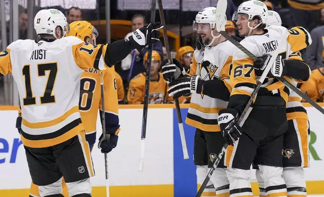 Pittsburgh Penguins defenseman Erik Karlsson, center, celebrates his goal with teammates during the third period of an NHL hockey game against the Nashville Predators, Thursday, Dec. 19, 2024, in Nashville, Tenn. The Penguins won 5-4 in overtime. (AP Photo/George Walker IV)