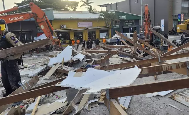 In this photo released by Department of Foreign Affairs and Trade (DFAT), Australian rescue workers inspect a damaged building in Port Vila, Vanuatu Thursday, Dec. 19, 2024, following a powerful earthquake that struck just off the coast of Vanuatu in the South Pacific Ocean. (DFAT via AP)