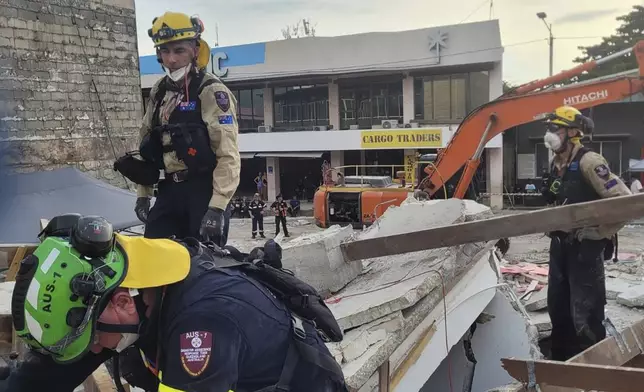 In this photo released by Department of Foreign Affairs and Trade (DFAT), Australian rescue workers inspect a damaged building in Port Vila, Vanuatu Thursday, Dec. 19, 2024, following a powerful earthquake that struck just off the coast of Vanuatu in the South Pacific Ocean. (DFAT via AP)