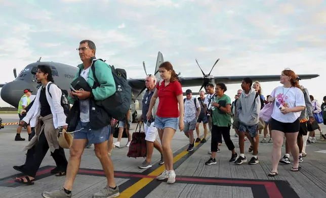 Australians stranded in Vanuatu following a powerful earthquake on Dec. 17, disembark from a Royal Australian Air Force plane at Brisbane International Airport in Brisbane, Australia, Thursday, Dec. 19, 2024. (David Clark/AAP Image via AP)