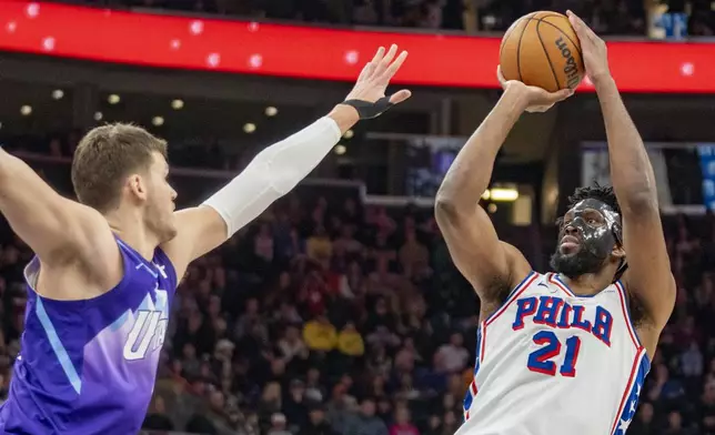 Philadelphia 76ers center Joel Embiid (21) looks to shoots over Utah Jazz center Walker Kessler, left, during the first half of an NBA basketball game Saturday, Dec. 28, 2024, in Salt Lake City. (AP Photo/Rick Egan)