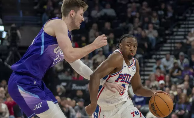 Philadelphia 76ers guard Tyrese Maxey (0) goes to the hoop as Utah Jazz forward Kyle Filipowski defends during the first half of an NBA basketball game Saturday, Dec. 28, 2024, in Salt Lake City. (AP Photo/Rick Egan)