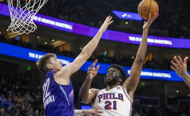 Philadelphia 76ers center Joel Embiid (21) shoots over Utah Jazz forward Kyle Filipowski (22) during the first half of an NBA basketball game Saturday, Dec. 28, 2024, in Salt Lake City. (AP Photo/Rick Egan)