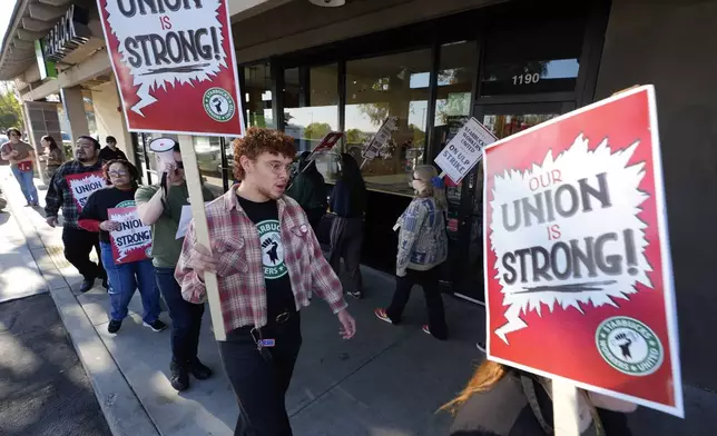 Starbuck workers picket outside of a closed Starbucks on Friday, Dec. 20, 2024, in Burbank, Calif. (AP Photo/Damian Dovarganes)