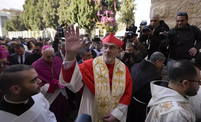 Latin Patriarch Pierbattista Pizzaballa, the top Catholic clergyman in the Holy Land, center, waves as he arrives at the Church of the Nativity, traditionally believed to be the birthplace of Jesus, on Christmas Eve in the West Bank city of Bethlehem, Tuesday, Dec. 24, 2024. (AP Photo/Matias Delacroix)