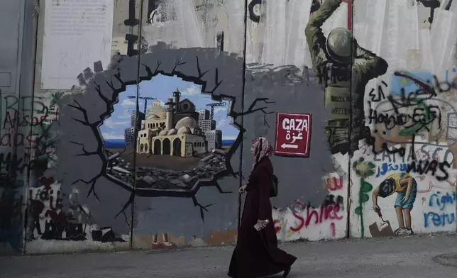 Murals cover Israel's separation barrier in the West Bank city of Bethlehem on Christmas Eve, Tuesday, Dec. 24, 2024. (AP Photo/Matias Delacroix)