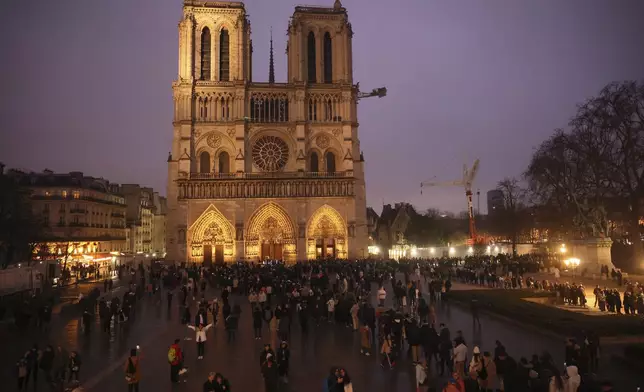 People queue to attend the mass at Notre Dame Cathedral as the monuments hosts Christmas Eve services for the first time since a devastating 2019 fire, Tuesday, Dec. 24, 2024 in Paris. (AP Photo/Thomas Padilla)