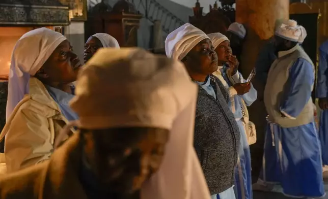 Nigerian worshippers pray in the Church of the Nativity, traditionally believed to be the birthplace of Jesus, on Christmas Eve, in the West Bank city of Bethlehem, Tuesday, Dec. 24, 2024. (AP Photo/Matias Delacroix)